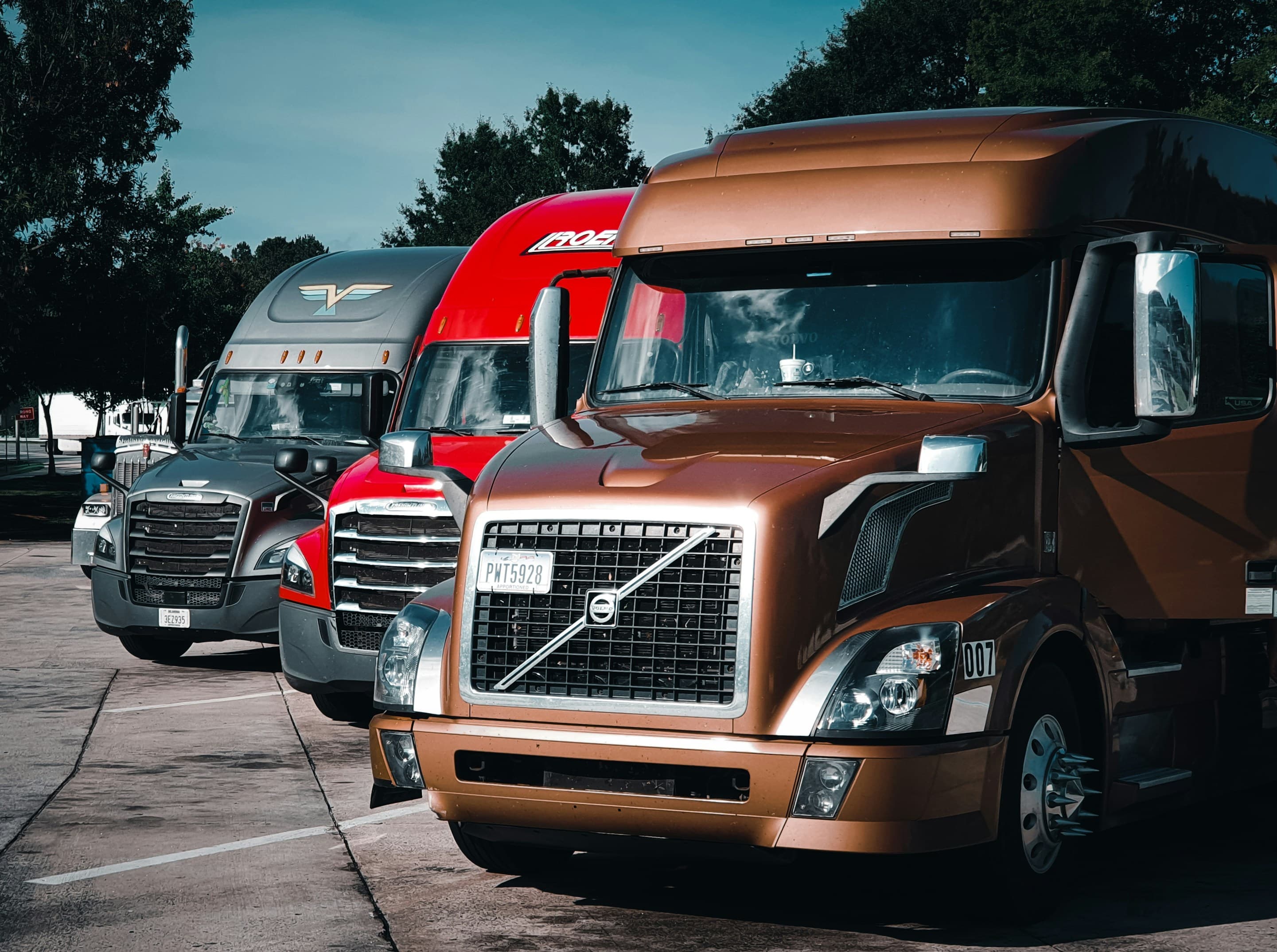 Line of commercial semi trucks parked at a fleet yard awaiting CARB compliance testing