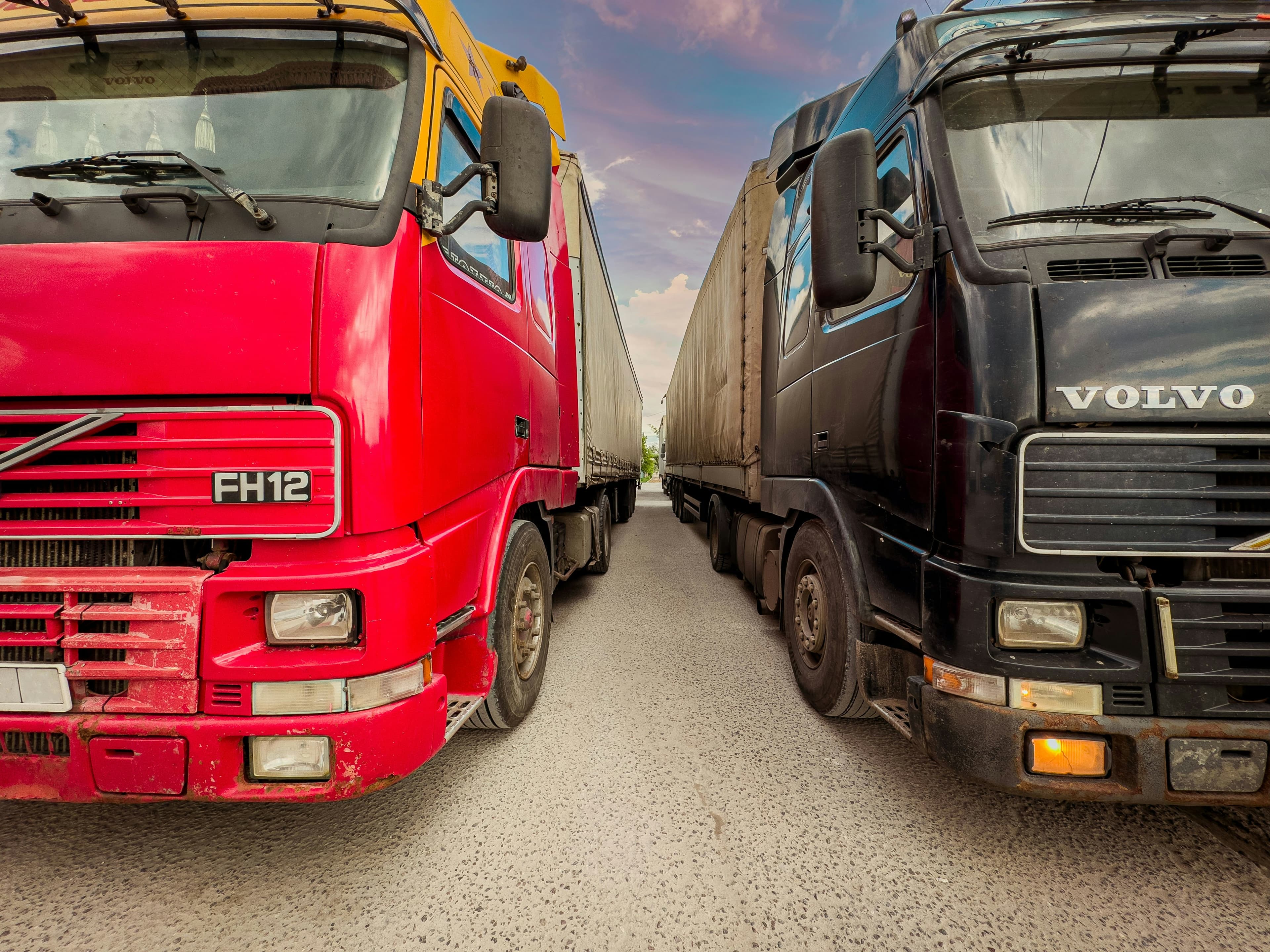 Red diesel truck parked beside another commercial truck during CARB emissions inspection